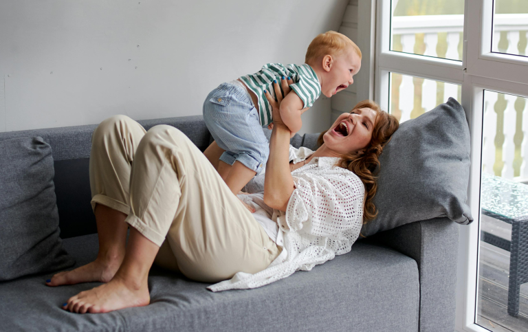 Mamma och bebis kommunicerar i en soffa.